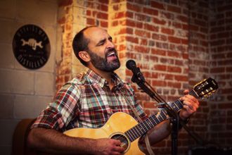 Live singer performing acoustic guitar for live entertainment background music at a company event cocktail party in Pawtucket, Rhode Island.