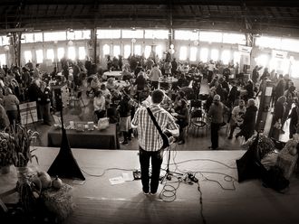 Solo singer guitarist performing at a brain injury non-profit fundraiser 5K run event in East Greenwich, RI in a large indoor venue with 100s of guests.