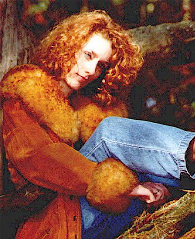 Heather Richards country singer-songwriter promotional photo for the Take a Chance on Me album, seated outdoors in a woodland setting.