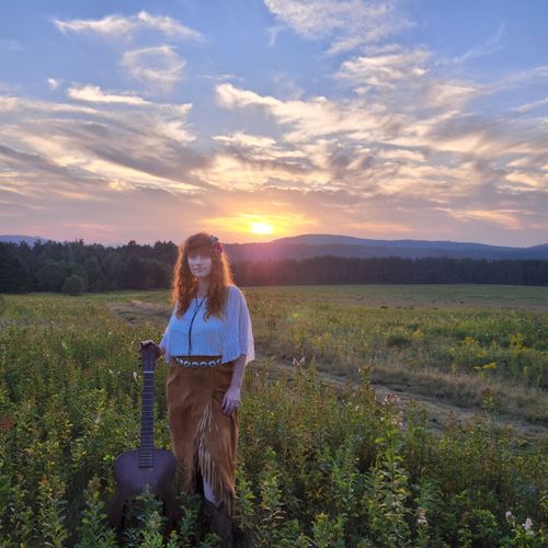 Heather Richards with guitar at Adirondack sunset meadow