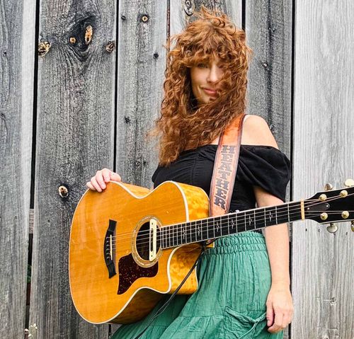 Heather Richards with acoustic guitar at Adirondack barn