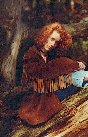 Heather Richards seated on a fallen tree in a woodland setting during the Take A Chance On Me era