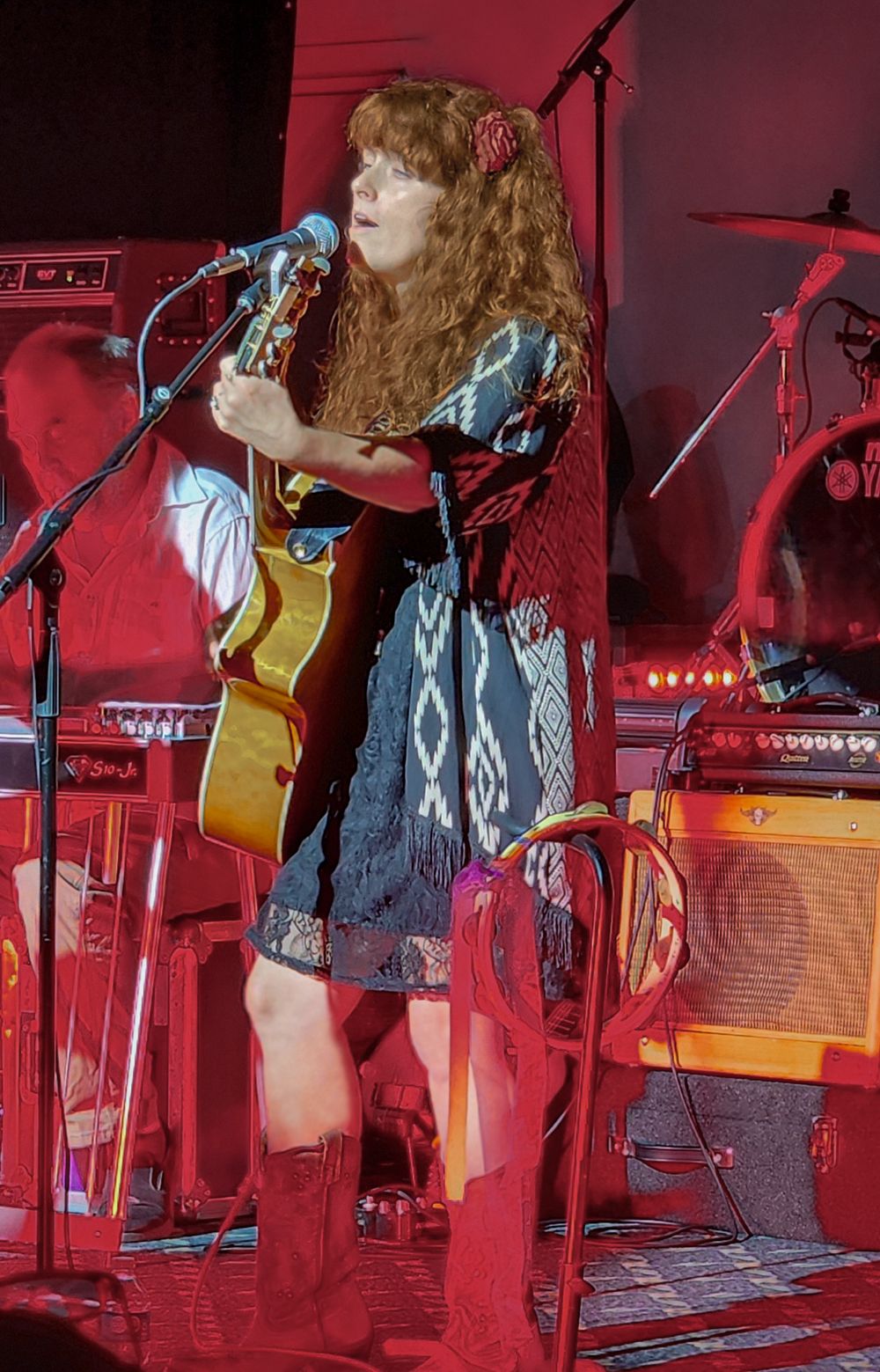Heather Richards performing live on stage with an acoustic guitar during a concert performance.