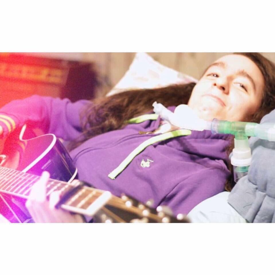 Photo of Zaina playing the guitar