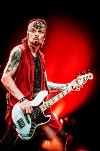 Aaron Leigh on bass with Y&T — red stage lighting.
