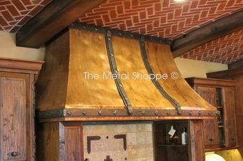 Close Up - Custom Large Rustic Hammered Copper Kitchen Range Hood. 48 oz. copper with welded seams. Forged iron trim with custom clavos.
