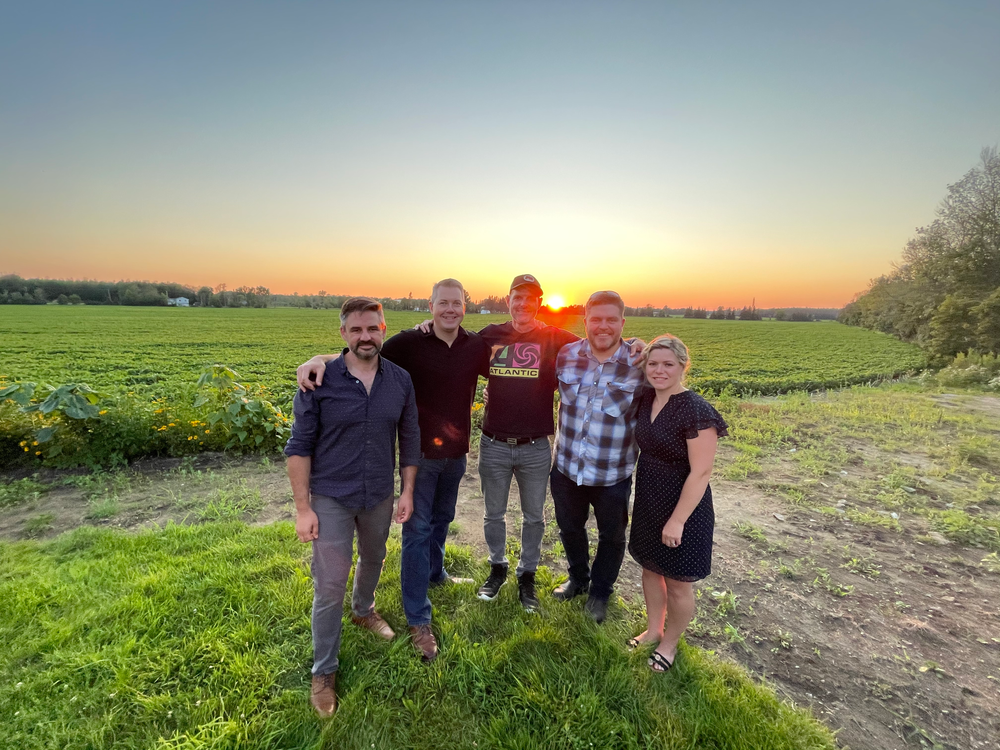 Group photo of Hadrian’s Wall featuring Ewen McIntosh, Neil Emberg, Richard Irwin, Terry O’Farrell and Ashley MacLeod-McRae at sunset in the countryside.