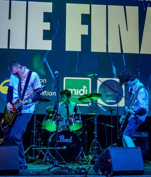 Nevik on stage at Battle of the Bands, supported by the Source Studio