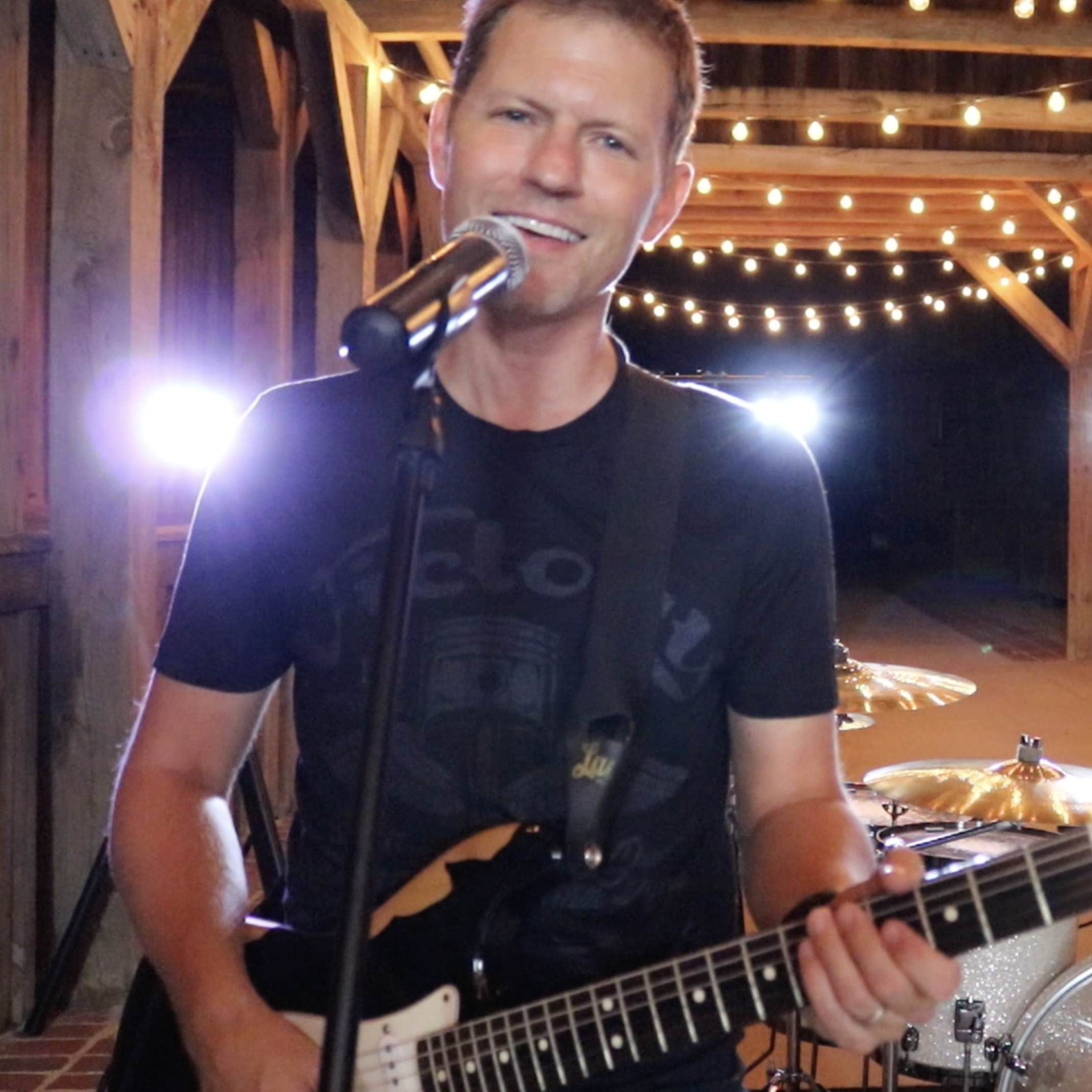 Chris Wold of 7 Sharp 9 singing and playing guitar at a wedding reception