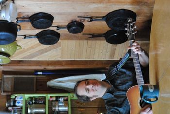 Sitting at the table, playing the guitar...
