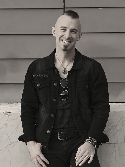 Man smiling with mohawk wearing black clothing