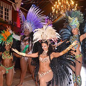 Four dancers in colorful feathered costumes giving a special performance