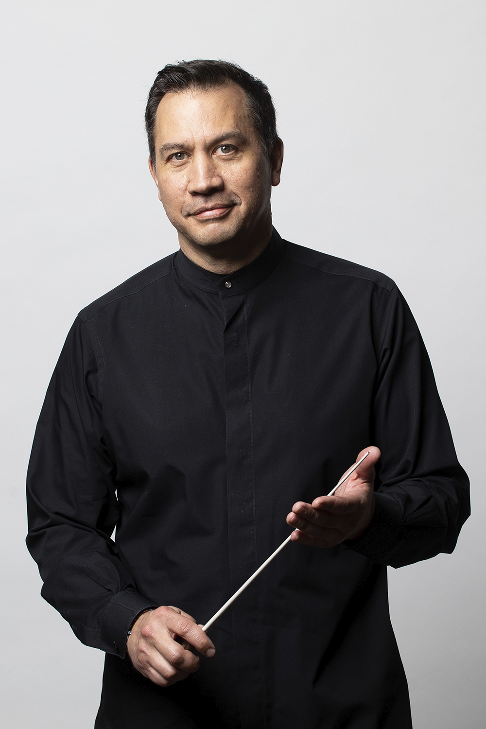 Conductor Daniel Hege, a Native American man in black holding a conductor's baton
