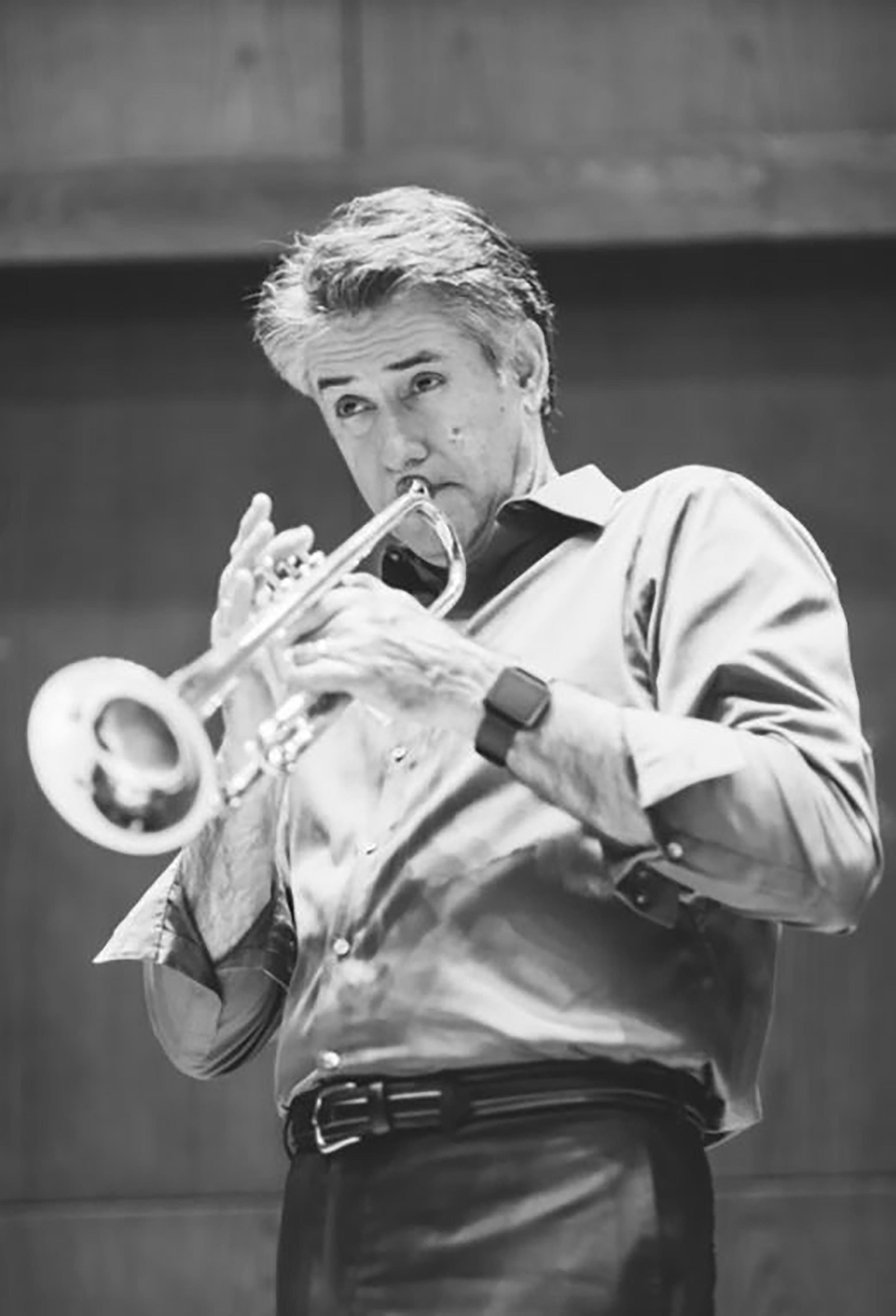Principal Trumpet Frank Campos, a white man with gray hair playing a trumpet