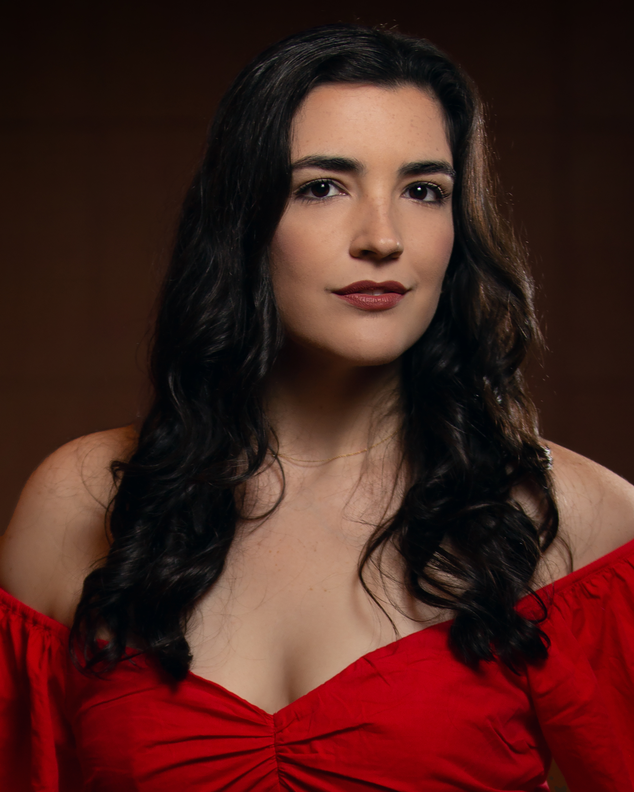 Soprano Sophia Hunt, a light-skinned woman with long brown hair and brown eyes in a strapless red gown
