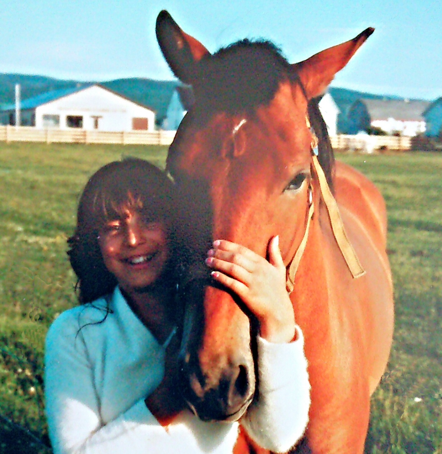A young Gaby Dufresne-Cyr holding her chesnut horse's nose in a hug 