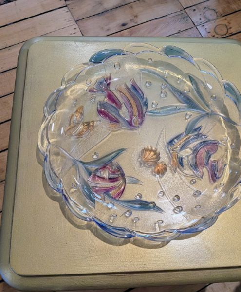 Glass plate with fish in a circle on a gold painted table