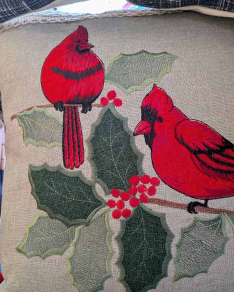 Two cardinals embroidered on a pillow
