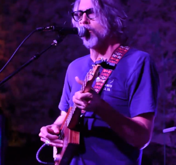 Scott Hall musician and songwriter singing and playing a cigar box guitar live
