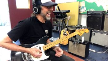 Scott Hall musician and songwriter in the studio holding a Fender Mustang guitar
