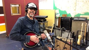 Scott Hall musician and songwriter in the studio holding a mandolin
