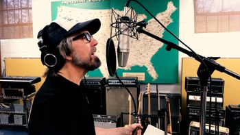 Scott Hall musician and songwriter in the studio singing
