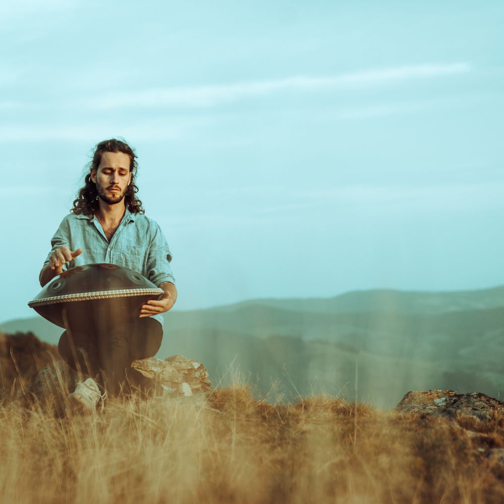 Alexander Mercks spielt Handpan auf einer Wiese vor Bergen – Handpan-Privatunterricht in Ehrenkirchen