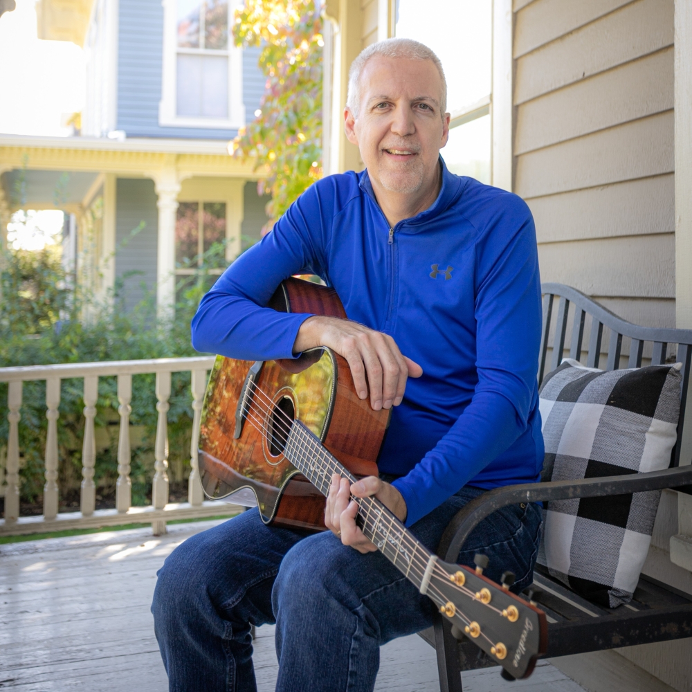 Mike Lucey Sitting on a Porch Bench with Breedlove Acoustic