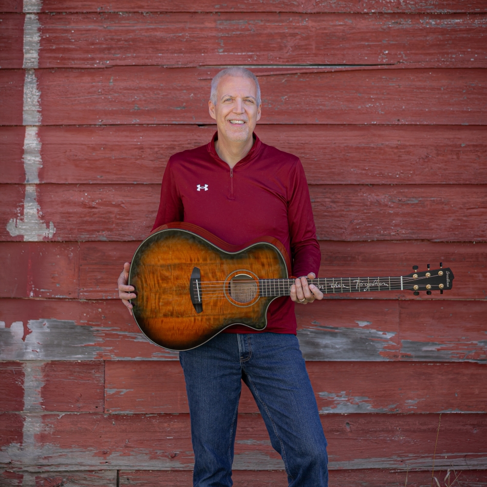 Mike Lucey Standing at a Red Barn with a Breedlove Acoustic