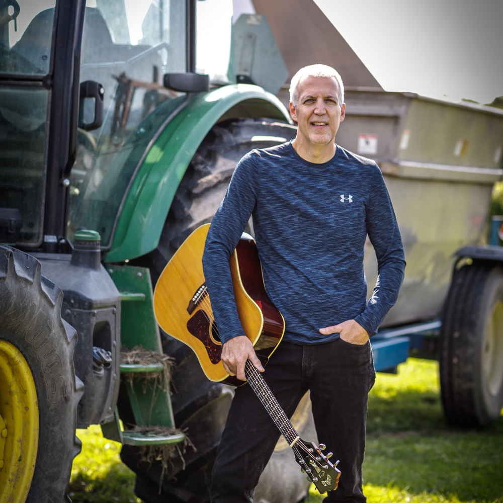 Mike Lucey in front of John Deere Tractor