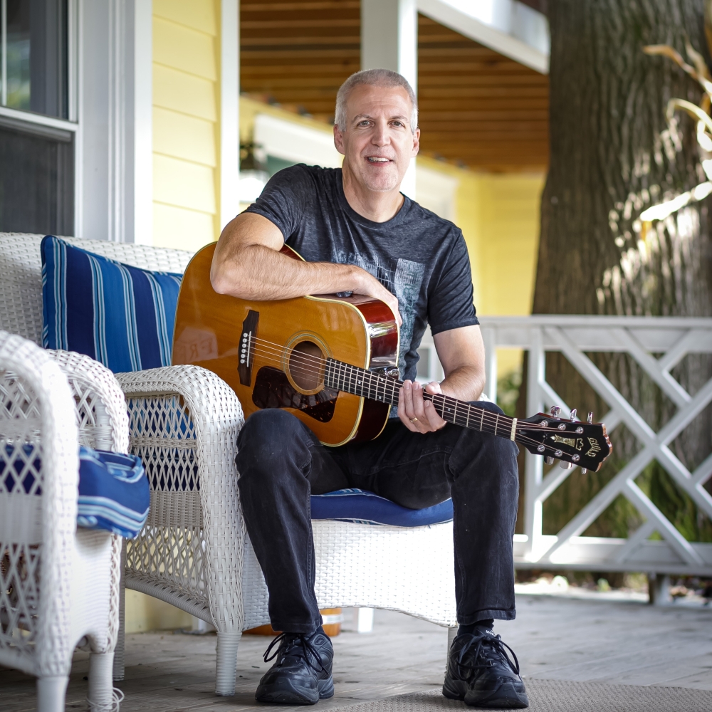 Mike Lucey on a Porch with a Guitar