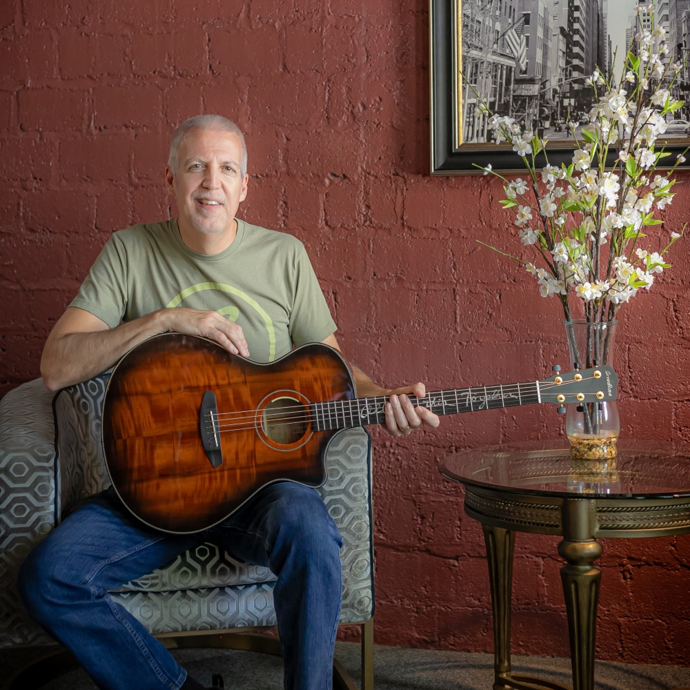 Mike Lucey Sitting with a Breedlove Acoustic Guitar
