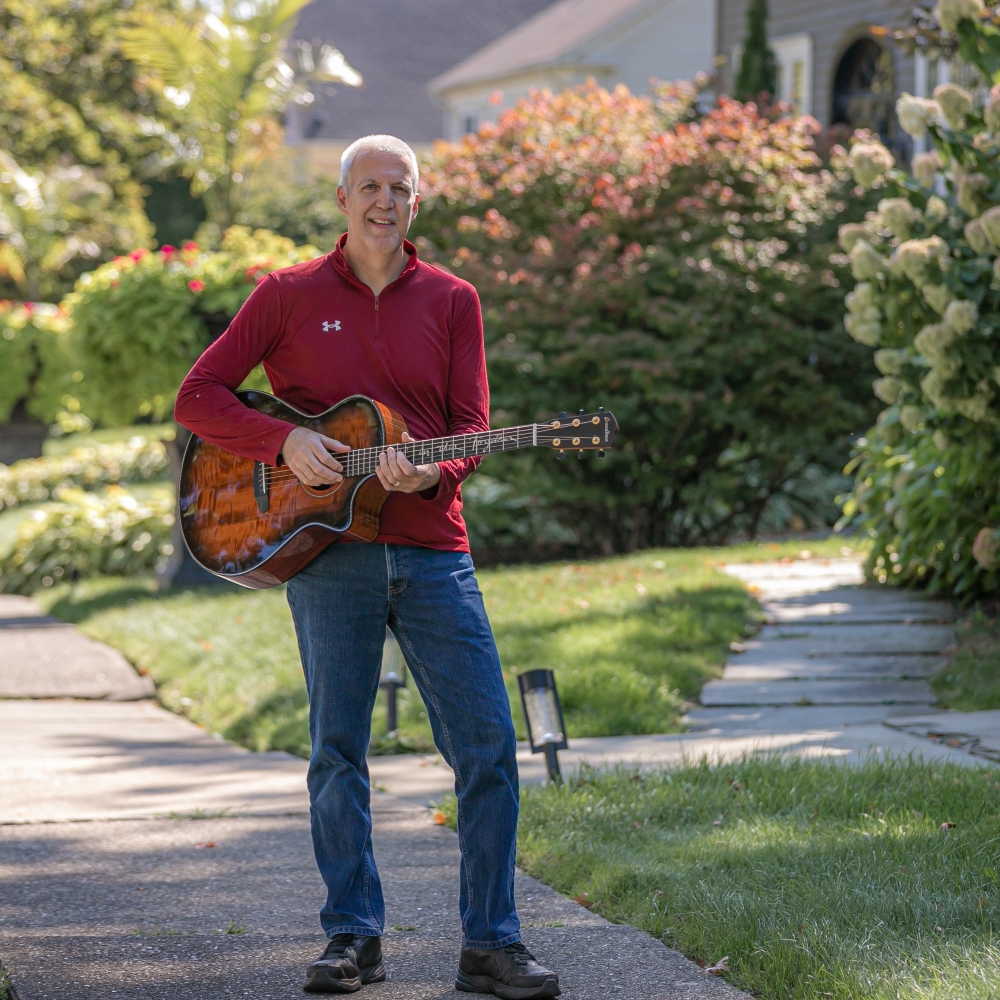 Mike Lucey Standing on a Sidewalk with Breedlove Acoustic