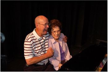 Jack Clark and Eloise Phillips fighting over the piano bench.
