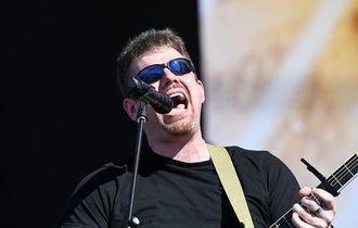 Derek Daisey singing into a microphone at a live performance