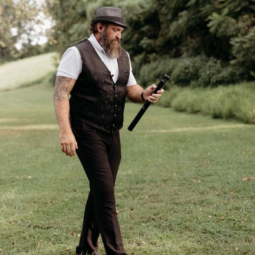 Crossroads Entertainment team member holding a handheld camera outdoors for wedding content creation.