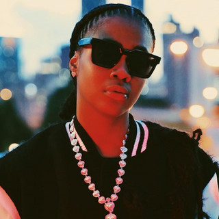 Amarri Noelle looking striking, dark wayfarer sunglasses, silver necklace, downtown skyscrapers in background