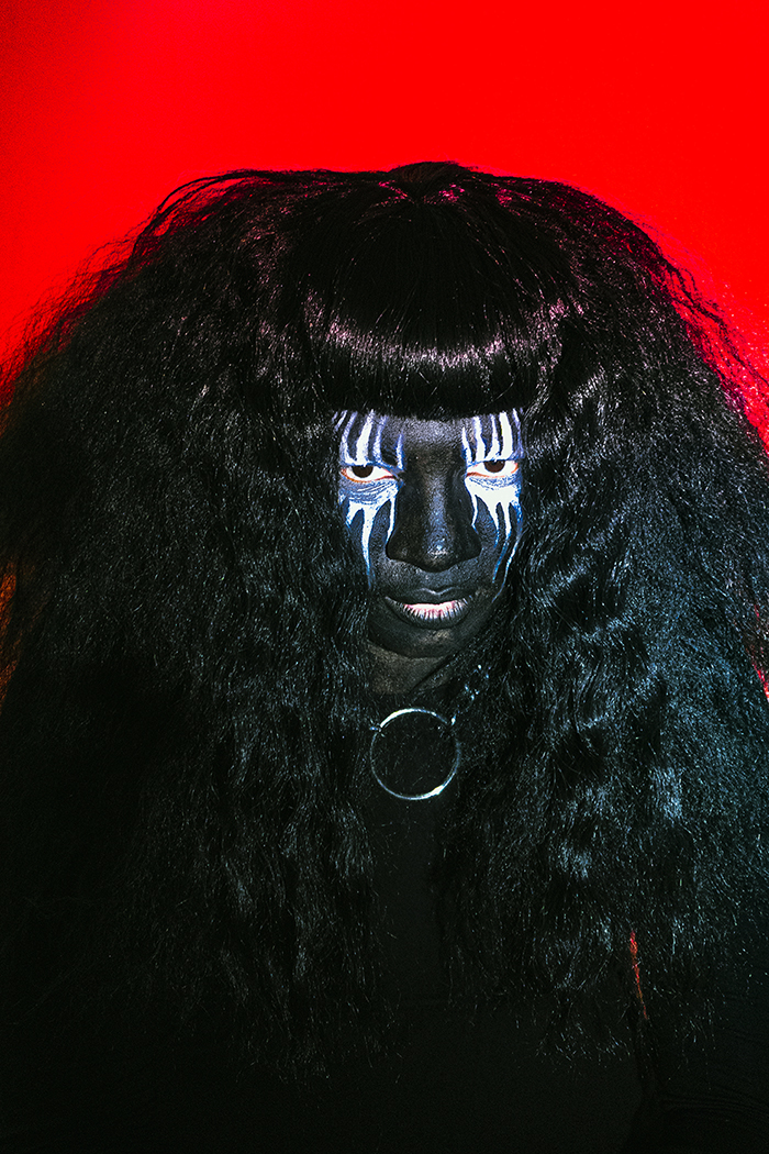 Backxwash in reverse corpse paint. All black, white around eyes, red background