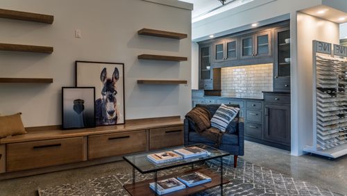 Our Omega living room display features Quartersawn White Oak floating shelves and built-in benches, utilizing minimalist slab drawer fronts for a clean, mid-century modern aesthetic
