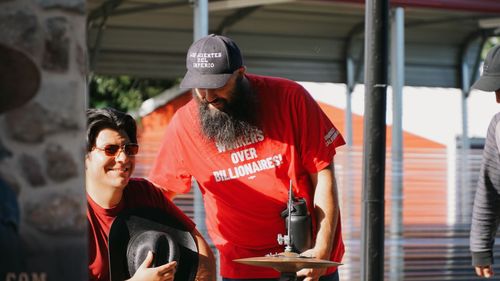 Jonny Miller Jr & Alexis Morelos leading workers in labor songs at IE Workers' Memorial Day 04-28-2026, at Lopez Urban Farm, Pomona, CA.
