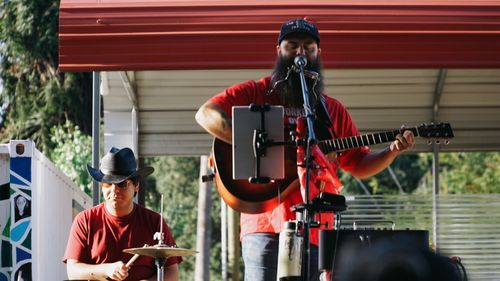 Jonny Miller Jr & Alexis Morelos leading workers in labor songs at IE Workers' Memorial Day 04-28-2026, at Lopez Urban Farm, Pomona, CA.