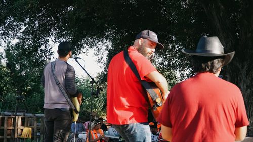 Hector "Max" Cruz, Jonny Miller Jr, & Alexis Morelos leading workers in labor songs at IE Workers' Memorial Day 04-28-2026, at Lopez Urban Farm, Pomona, CA.