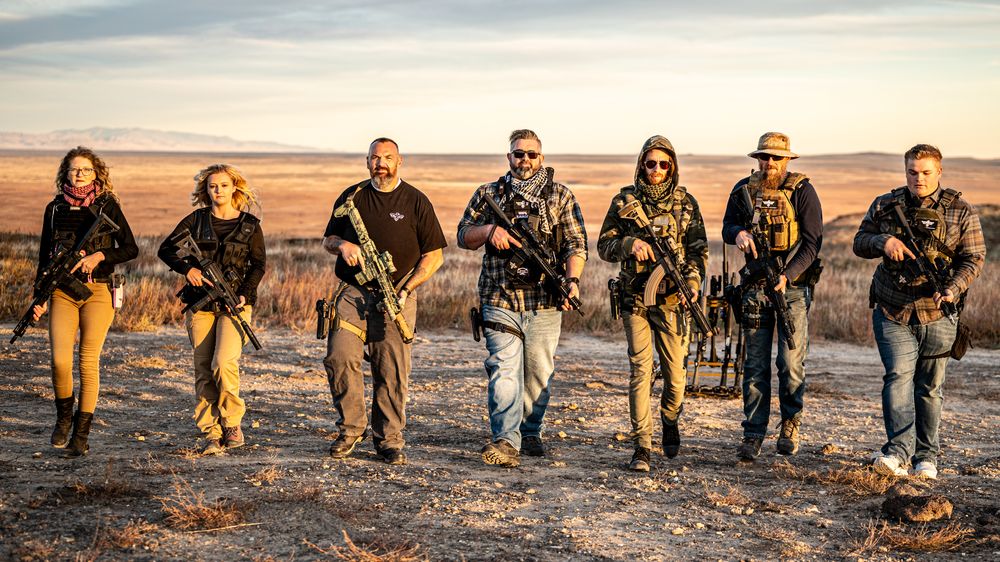 seven TVSA team members- the 4 Owner/Operators/Chief Instructors, Women's instructor, and two volunteers walking forward with their rifles for a professional photo 