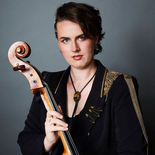 Portrait of Lea Kirstein of Medusa Quartet with cello, dressed in black and gold.