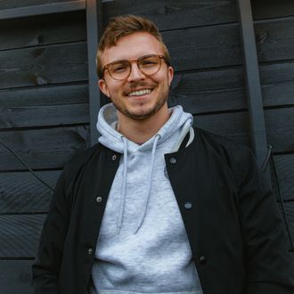 Codey Lee James  stands before a wooden background.