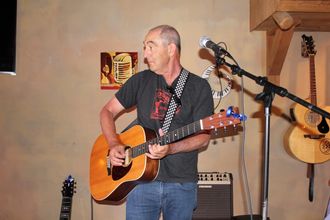The Back Pages guitarist performing live on acoustic guitar, western Washington