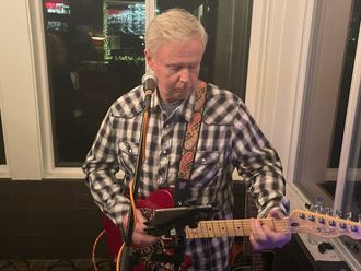 The Back Pages guitarist playing electric guitar on stage