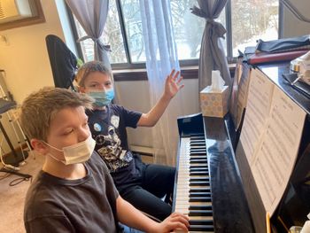 Sibling students learning to play duets
