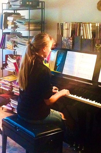 Teen student learning to play her first Christmas carols at the piano
