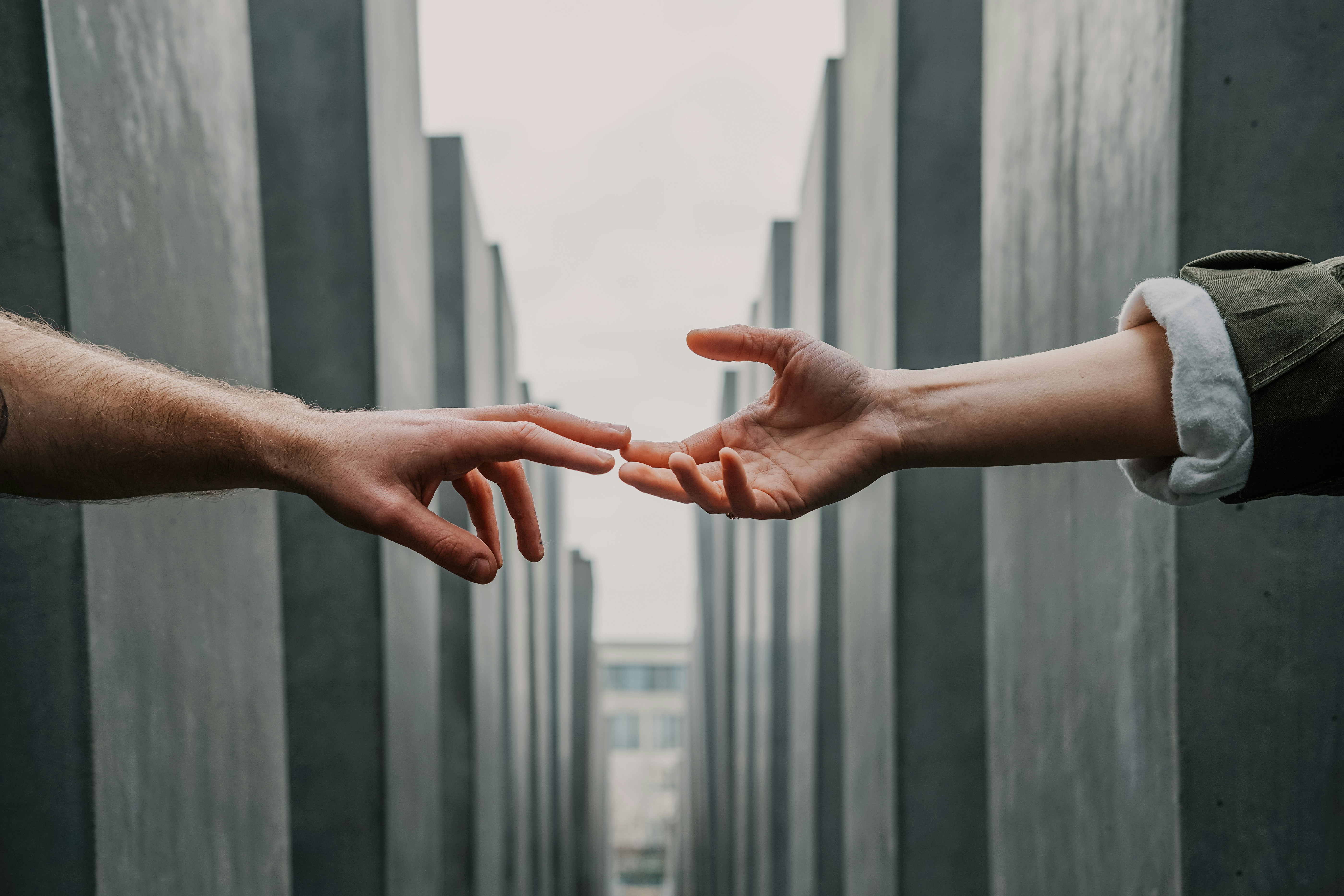 Two hands reaching out across a void, fingers touching